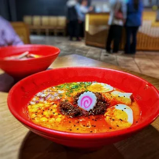 Iso Iso Ramen $13.99 - spicy creamy chicken broth, spiced ground beef, marinated egg, naruto,  corn, scallions, red onions, sesame seeds.