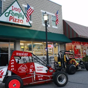two race cars parked in front of a store