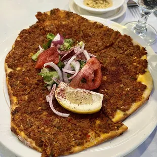 a pizza with a slice of lemon on top