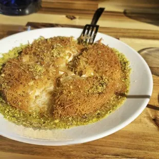 Kunefe- crispy cheese-filled dessert made with kadayıf (kah-dah-YUF&apos;), which is a traditional shredded wheat dessert with pistachio filling.