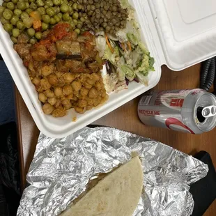 vegetable meal with chickpeas, eggplant, peas, lentils, salad, bulgur, and pita bread.
