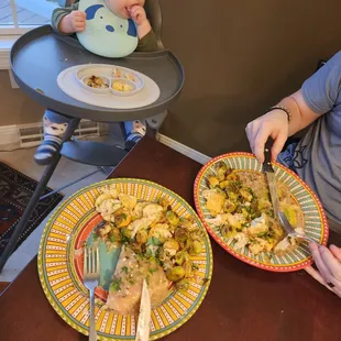 a child in a highchair with a plate of food