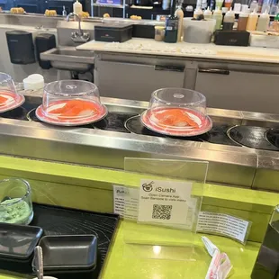 a row of sushi plates on a conveyor belt