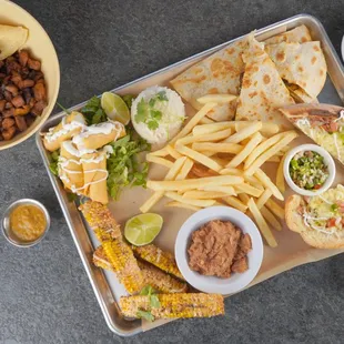 Tray Garnachero for 2 or 4 people. Quesadillas, corn ribs, fries, flautas, molletes, tacos, rice, beans, guac and salsa!