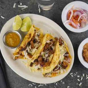 Cochinital Pibil tacos, achiote marinated pork and served with pickled habanero and red onion.