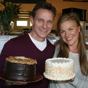 a man and a woman holding a cake