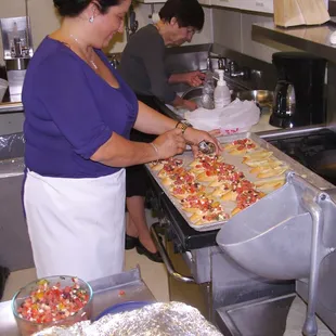 a woman preparing food in a commercial kitchen