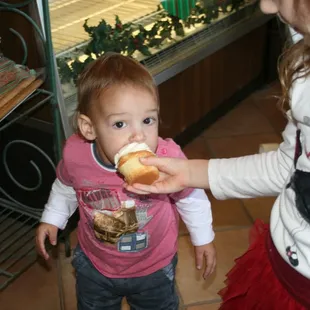 a toddler eating a hot dog