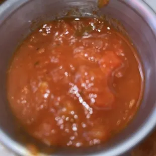 a bowl of tomato sauce on a plate