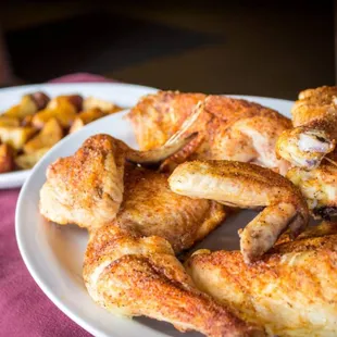 a plate of chicken wings and potatoes