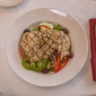 a plate of salad with chicken and vegetables