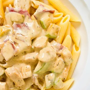 a plate of pasta with chicken and sauce