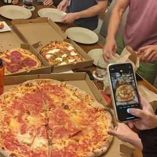 a person taking a picture of a pizza