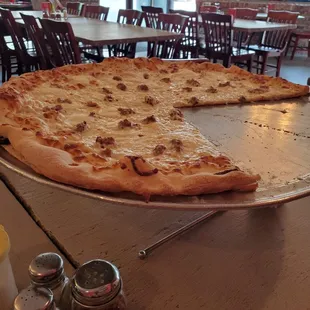 Large white pizza with sausage.