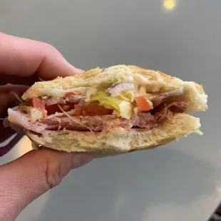 a hand holding a sandwich