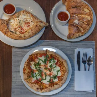 three plates of pizza and a croissant