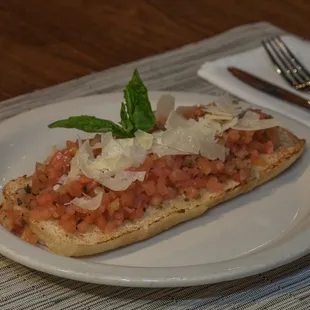 a slice of bread topped with tomatoes and cheese