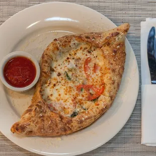 a slice of pizza on a plate with a side of ketchup