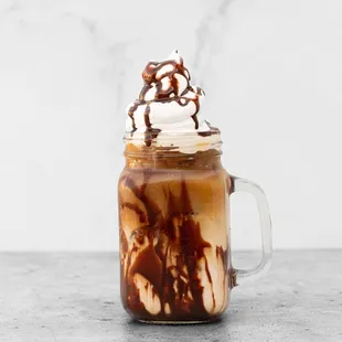 an iced coffee with whipped cream and chocolate syrup