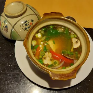 a bowl of soup and a teapot