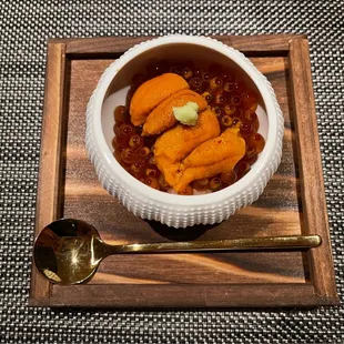 a bowl of food on a tray with a spoon