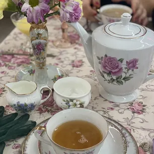 a table setting with tea and flowers