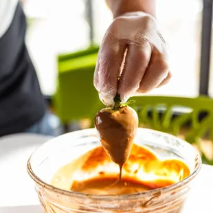 a person dipping something into a bowl