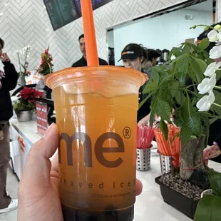 a hand holding a cup of boba