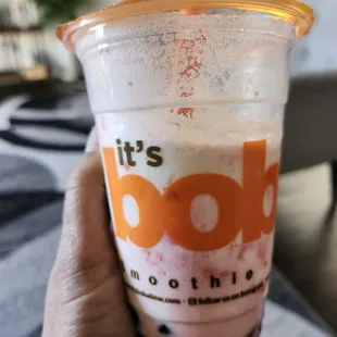  hand holding a cup of boba