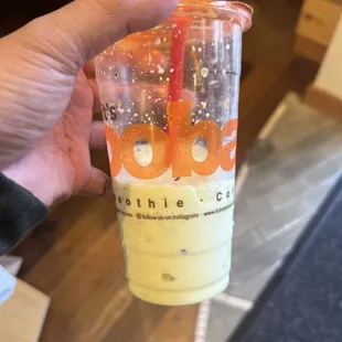 a hand holding a cup of boba