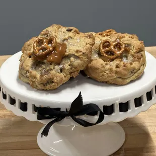 two cookies on a cake stand
