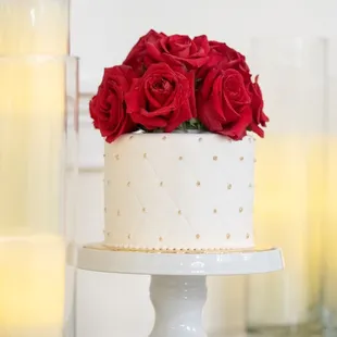 a wedding cake with red roses