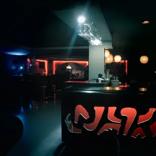 a bar with a neon sign in the dark