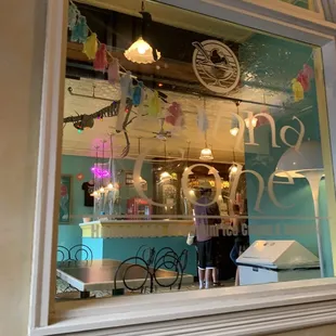 the reflection of a woman in a shop window