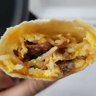 Breakfast burrito with sausage, egg, cheese, and hash browns, no green chilies, added bacon