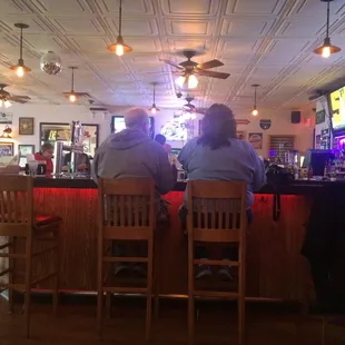 Bar with booth and high top seating surrounding it. Small place, clean, friendly.