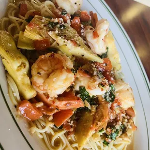 a plate of pasta with shrimp and vegetables