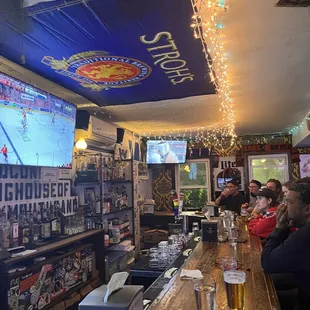 people sitting at a bar watching television