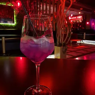 a purple drink in a wine glass