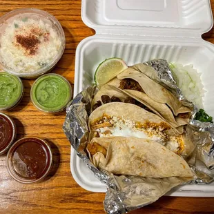 Tacos (flour tortilla). We got carne asada, mole, pollo, and pescada.  That&apos;s esquites (corn) on the left.