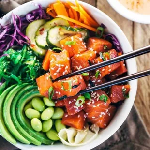 a bowl of sushi with chopsticks