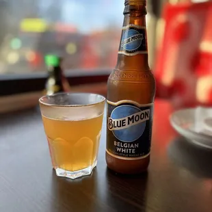 a glass of beer and a bottle on a table