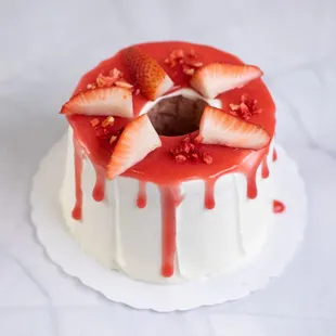 a strawberry covered cake on a white plate