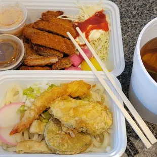 two takeout containers of food and a cup of tea