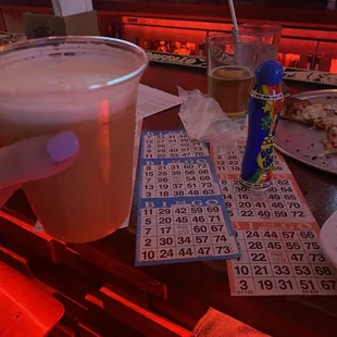 a person's hand holding a cup of beer
