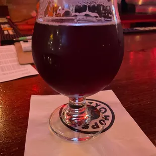 a glass of beer on a napkin