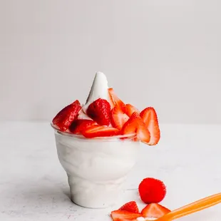 a bowl of strawberries and whipped cream