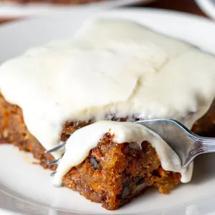 a slice of carrot cake on a plate with a fork