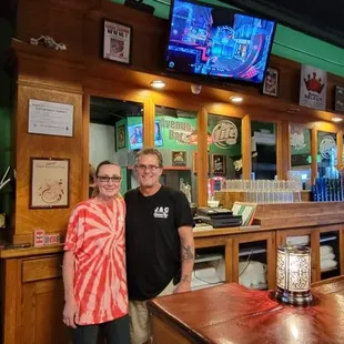  two people standing at the bar