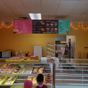 two children looking at a display of donuts